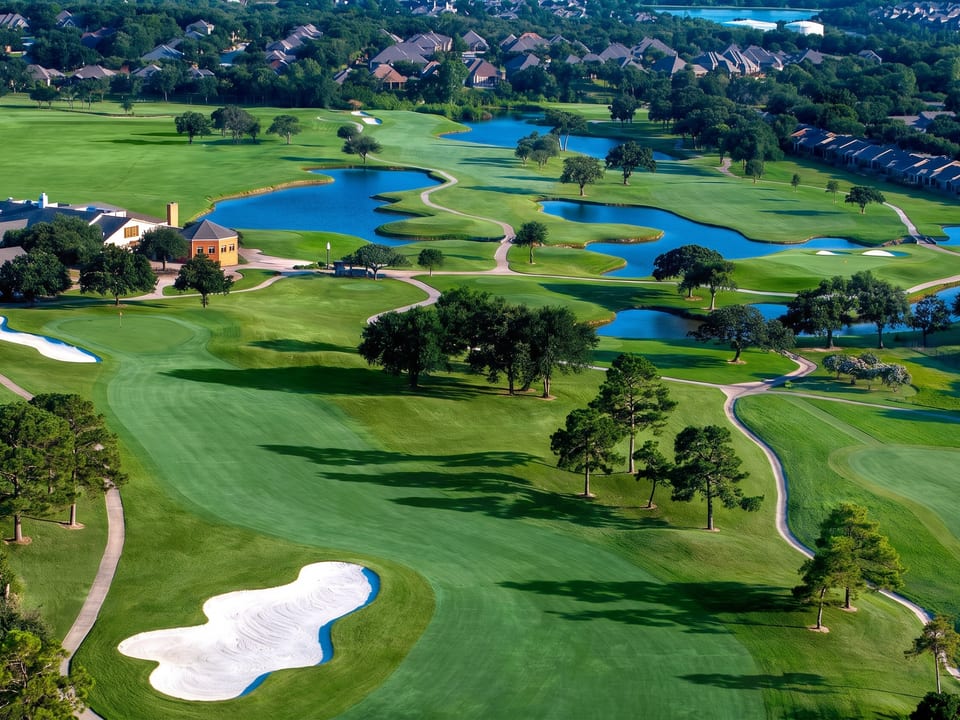 An aerial view of the Oakmont golf course in Corinth, Texas, with fairways, ponds and sand bunkers ringed by homes.