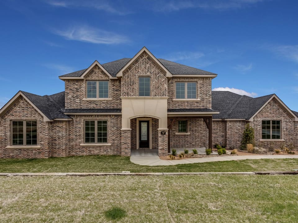 A two-story North Texas brick home with a covered entry.