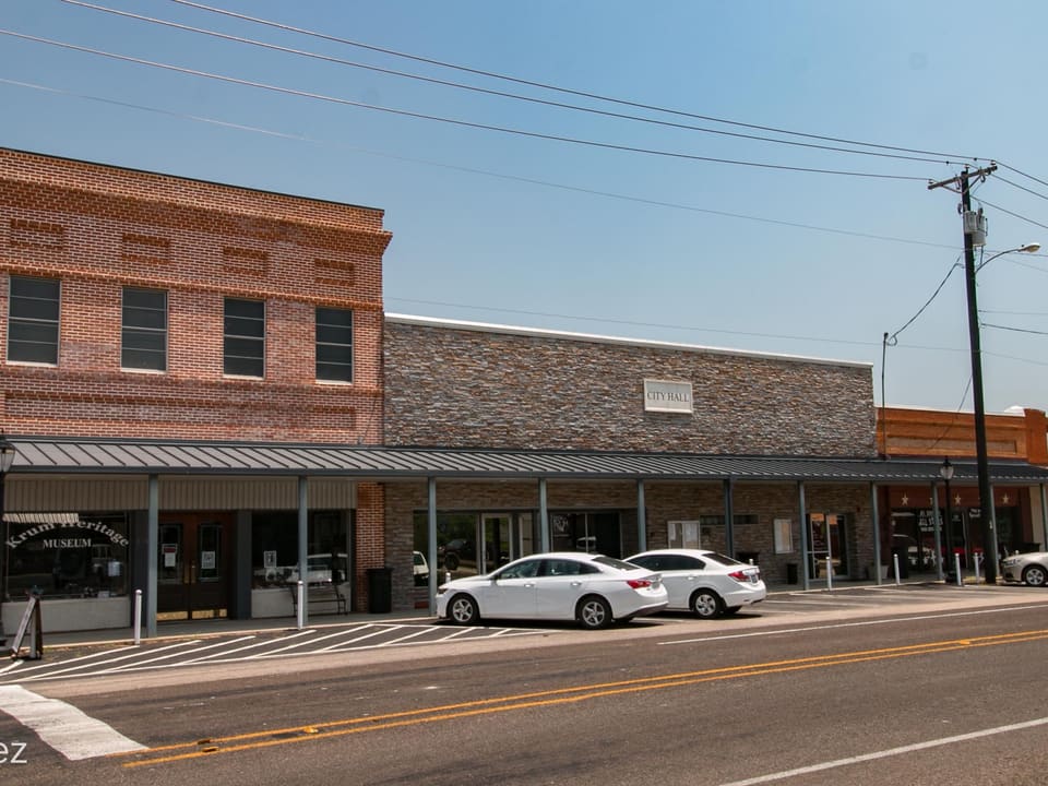 The brick City Hall and Heritage Museum storefronts in downtown Krum, Texas.