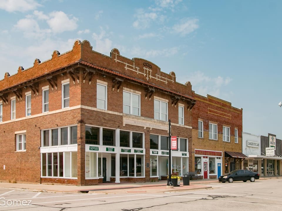 The historic two-story brick Wilfong Building on a corner in downtown Sanger, Texas.