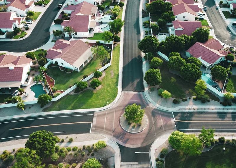 Large custom homes along a landscaped suburban street.